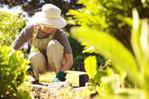 Team member with protective gloves and high-visibility jacket in a garden